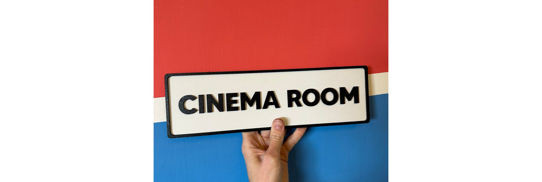 Hand holding a sign with Cinema Room written on it