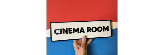 Hand holding a sign with Cinema Room written on it