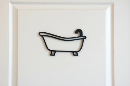A black acrylic bathroom door sign on a white door