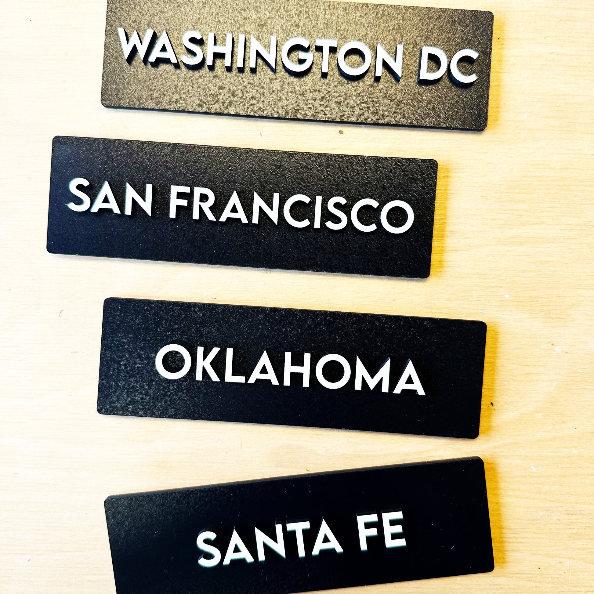 Black background with white letters city names signs