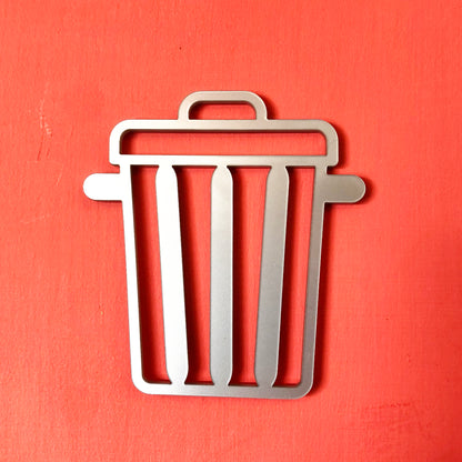Metal trash bin door sign in silver on a coral background