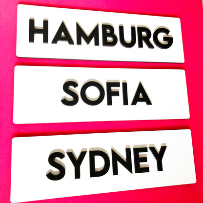 White signs with black letters world city name signs