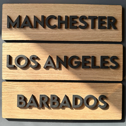 Wooden plaques with city names on a gray background